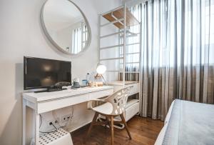 a bedroom with a desk with a television and a mirror at Loulé Coreto Guesthouse in Loulé