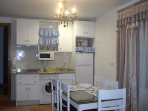 a kitchen with a table and chairs and a microwave at Posada del Teso, Norte provincia Cáceres, Tierras de Granadilla TR-CC-00153 in Cerezo