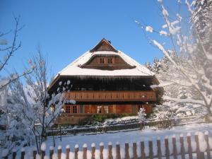 a large building covered in snow with a fence at Der Lautenbachhof in Bad Teinach-Zavelstein