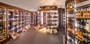 una tienda de vinos con estanterías de botellas de vino en Il Boscareto Resort & Spa, en Serralunga d'Alba