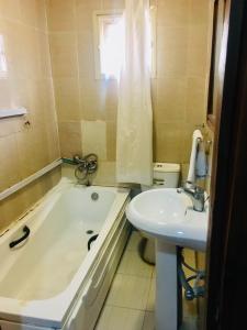 a bathroom with a bath tub and a sink at Light House Hotel in Lekki