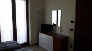 a bedroom with a dresser with a television on it at Laghetto ai Portici in Pastrengo