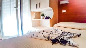 una camera con due letti e occhiali da sole sul letto di Hotel Condor a Milano Marittima