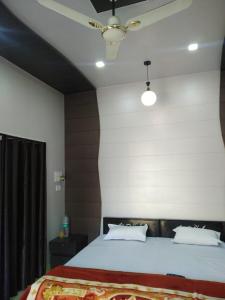 - une chambre avec un grand lit et un plafond dans l'établissement Radha Krishna Dham, à Vrindavan