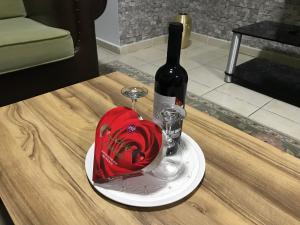 een fles wijn en een hartvormige taart op een tafel bij Royal Residence Kyrenia in Kyrenia
