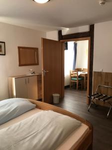 
a bedroom with a bed and a dresser at Hotel Guntia in Günzburg
