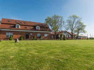 a large brick house with a large grass field at Dworek u Leszczyńskich in Gościszewo