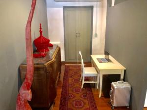 Habitación con mesa y escritorio con objeto rojo. en Nakara Loft Chiangmai, en Chiang Mai