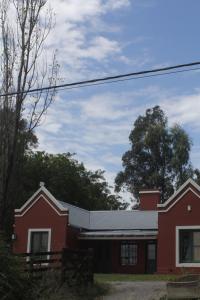 una casa roja con techo blanco en Quinta El Monte en Tandil