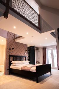 una camera con un grande letto con testiera in legno di The Jacobean Hotel a Coventry