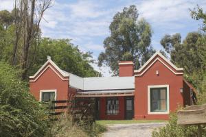 una casa roja con techo blanco en Quinta El Monte en Tandil