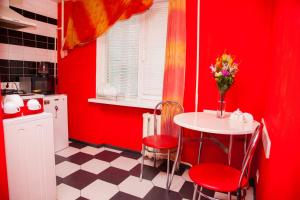 ザポリージャにある2Rooms Semi-luxury Apartment on Pochtovaya 167-A Streetの赤い壁のキッチン(テーブル、椅子付)