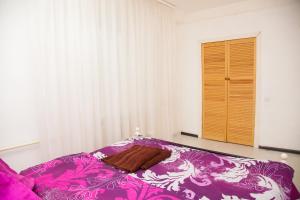 a bedroom with a purple bed with a wooden door at 2Rooms Semi-luxury Apartment on Pochtovaya 167-A Street in Zaporozhye