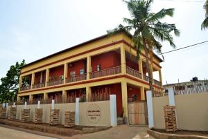 un edificio rojo con una palmera delante en somewhere nice en Accra