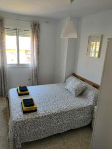 um quarto com uma cama com duas placas amarelas em Vivienda cercana a la playa con todas las comodidades em Tarifa