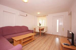 ein Wohnzimmer mit einem Sofa und einem Tisch in der Unterkunft Apartmani Bradaric in Pula