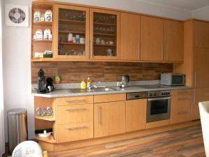 una cocina con armarios de madera y fregadero en Ferienwohnung Zur Mühle en Weener