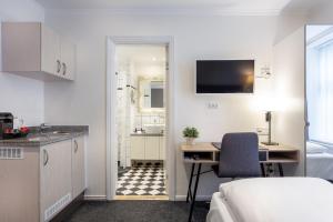 a room with a kitchen and a desk and a bed at Hotel Tiffany in Copenhagen
