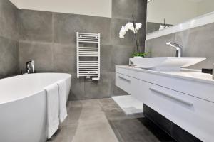 a bathroom with two sinks and a bath tub at Le Spinaker in Le Grau-du-Roi