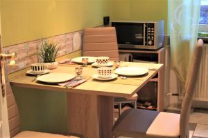 eine Küche mit einem Tisch mit Tellern und einer Mikrowelle in der Unterkunft MA-LIVING Villa Elenor in Mainz