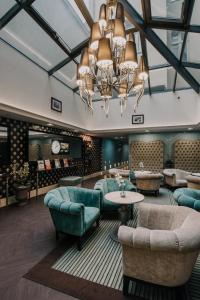 a lobby with a chandelier and chairs and a table at La Prima Fashion Hotel Budapest in Budapest