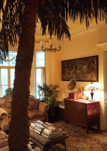 a living room with a palm tree and a table at Auberge King Edward Bed and Breakfast in Ottawa