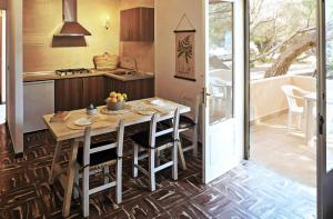 a kitchen with a wooden table and chairs and a kitchen with a sink at Apartamento Ses Botges - Formentera Break in Es Caló