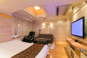 a hotel room with a bed and a flat screen tv at HOTEL D-WAVE Shinjuku（Adult Only) in Tokyo