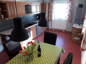 a kitchen with a table with a vase of flowers on it at Ferienwohnung am Pochebach in Kurort Jonsdorf