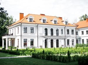 una gran casa blanca con techo naranja en Hotel Usadba, en Kaliningrado