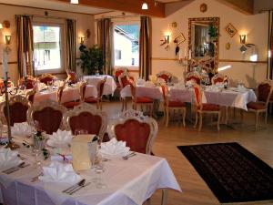 een eetkamer met tafels en stoelen met witte tafelkleden bij All Inclusive Hotel Sonnenhügel in Sattendorf