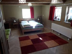 - une chambre avec un lit et un tapis en damier dans l'établissement Ferienwohnung am Pochebach, à Jonsdorf