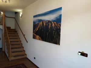 une photo d'une montagne suspendue sur un mur dans l'établissement Pensiunea Kyfana Zarnesti, à Zărneşti