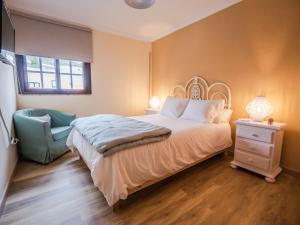 a bedroom with a large bed and a chair at ElHierroBed&Chic in Valverde