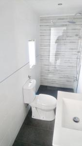 een witte badkamer met een toilet en een wastafel bij Villa Calle Montecillo in Alhaurín el Grande