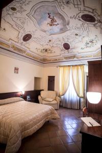 a bedroom with a bed and a ceiling with paintings at Hotel San Claudio in Corridonia