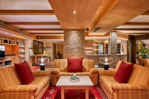 uma sala de estar com sofás e uma mesa em Hotel Portavescovo em Arabba