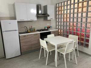 a kitchen with a white table and white appliances at Dione in Siracusa