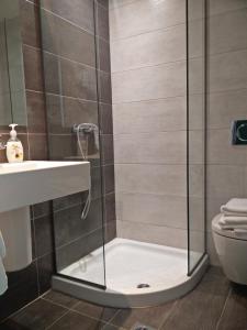 a shower with a glass door next to a toilet at New York Hotel in Rhodes Town