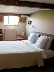 a bedroom with a large bed with white sheets and pillows at Boutique hotel Sint Jacob in Maastricht