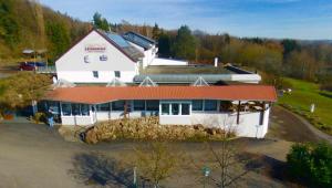 an aerial view of a white building with a red roof at Hotel Restaurant Litermont in Nalbach