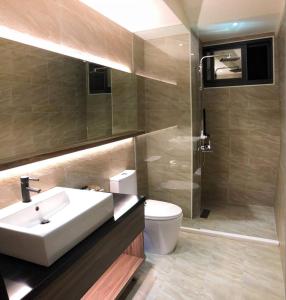 a bathroom with a sink and a toilet and a shower at Lantan Fanyue Inn in Chiayi City