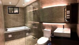 a bathroom with a toilet and a sink and a shower at Lantan Fanyue Inn in Chiayi City