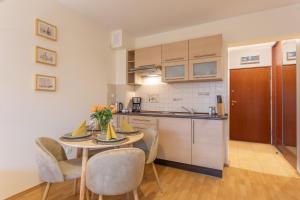a kitchen and dining room with a table and chairs at Ambria Apartments Promenada in Świnoujście