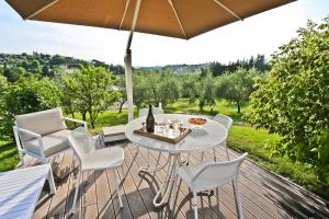 un patio con mesa, sillas y sombrilla en Poggio Baronti B&B, en Bagno a Ripoli