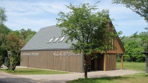 a large wooden barn with a gambrel roof at Kassari Apartment in Hiiumaa