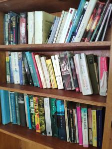una estantería llena de libros en Harmony Bay Resort and Dive Center en Wakai
