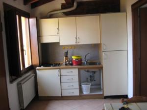 eine Küche mit weißen Schränken und einem Waschbecken in der Unterkunft Altana Piccionaia di Via Dante in Cremona