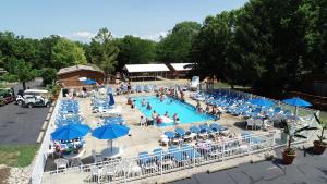 a swimming pool with people sitting in chairs and umbrellas at Island Club #80 in Put-in-Bay