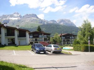 zwei Autos auf einem Parkplatz vor einem Gebäude geparkt in der Unterkunft L'Onyx - Domaine de Nant Cruy in Sallanches